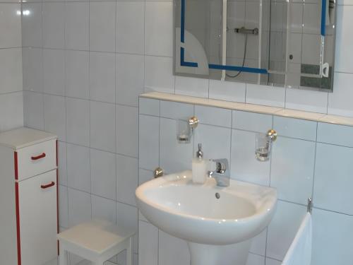 a white bathroom with a sink and a mirror at Ferienwohnung Sonnenblick in Eisenbach