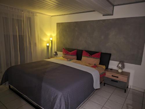 a bedroom with a large bed with red pillows at Ferienwohnung Sonnenblick in Eisenbach
