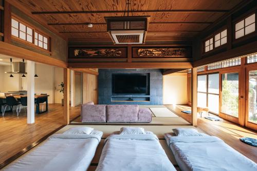 ein Wohnzimmer mit zwei Betten und einer Couch in der Unterkunft ゆたか in Kajiya