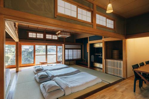 ein Schlafzimmer mit einem großen Bett in einem Zimmer mit Fenstern in der Unterkunft ゆたか in Kajiya