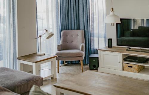 a living room with a chair and a television at Lobster in Egmond aan Zee