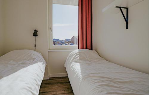 two beds in a room with a window at Saskerlei in Uitgeest