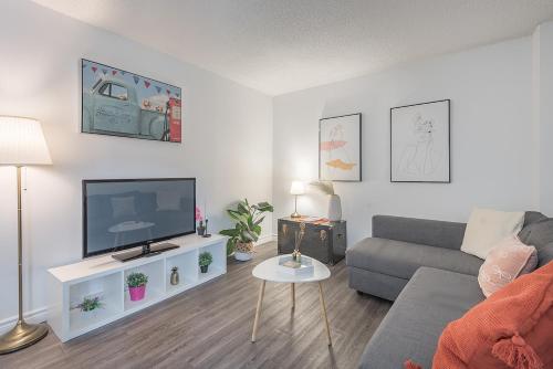 a living room with a couch and a flat screen tv at Spacious and Cozy 1BR - Near Old Port in Montréal