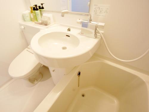 ein weißes Bad mit einem Waschbecken und einem WC in der Unterkunft Hotel Trend Asakusa in Tokio