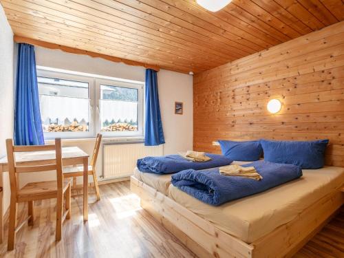 two beds in a room with a wooden wall at Haus Joachim in Längenfeld