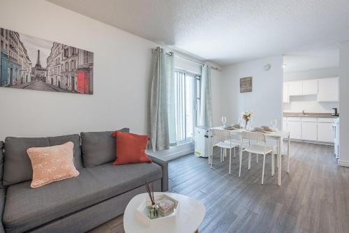 a living room with a gray couch and a kitchen at Spacious and Cozy 1BR - Near Old Port in Montréal