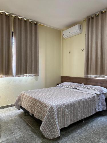 a bedroom with a bed with a blanket on it at Apto lindo em Alter do chão in Alter do Chao