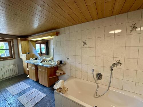 a bathroom with a tub and a sink at Schwarzmann in Mellau