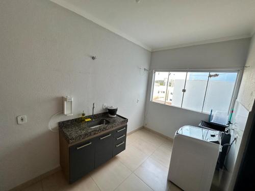 a small kitchen with a sink and a window at Apto próx Hospital Regional até 6 pessoas com garagem e wifi in Nova Mutum