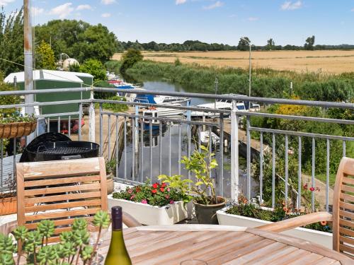 eine Terrasse mit Pflanzen und einer Flasche Wein in der Unterkunft The Boat House in Canterbury