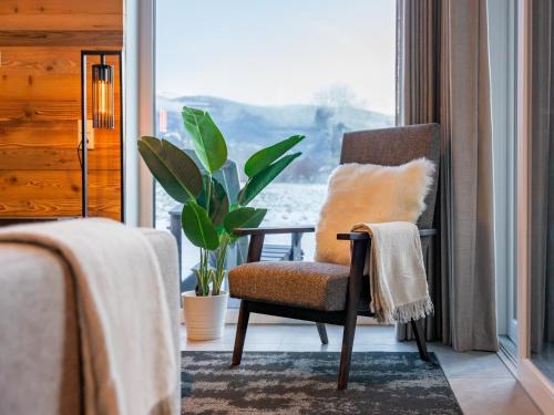 une chaise assise dans une pièce avec fenêtre dans l'établissement Mountain Chalet Aquarius 5B, à Sankt Lorenzen ob Murau