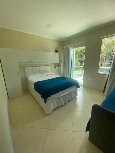 ein Schlafzimmer mit einem Bett mit einer blauen Decke darauf in der Unterkunft Linda casa em Tarituba in Paraty