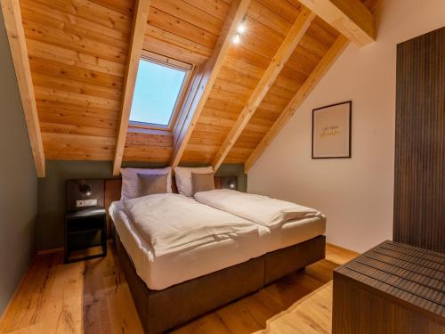 un lit dans une chambre avec un plafond en bois dans l'établissement Mountain Chalet Aquarius 5A, à Sankt Lorenzen ob Murau