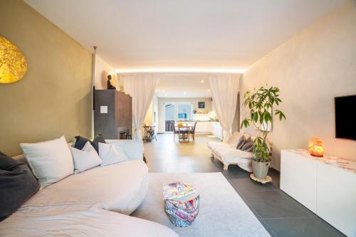 sala de estar con sofás blancos y TV en Lieblingsplatzl, en Naturno