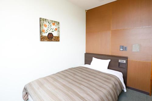 a bedroom with a bed and a picture on the wall at ホテルララプラス in Nirasaki