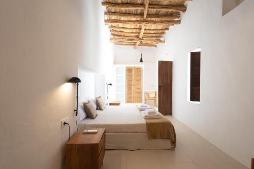 a bedroom with a large bed and a wooden table at Can Tunio , Santa Gertrudis in Illes Balears