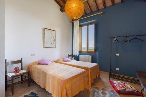a bedroom with two beds and a blue wall at La Ripa - Appartamento I Ghiri in San Gimignano