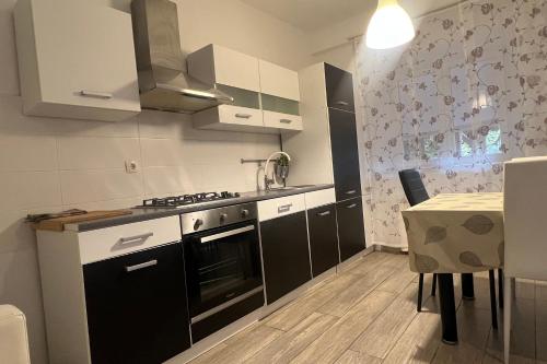 a kitchen with black and white cabinets and a table at Apartments by the sea Novigrad - 24877 in Novigrad Istria