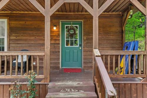 a wooden cabin with a green door on a porch at Sundance Cabin with Hot Tub and WiFi in Slade