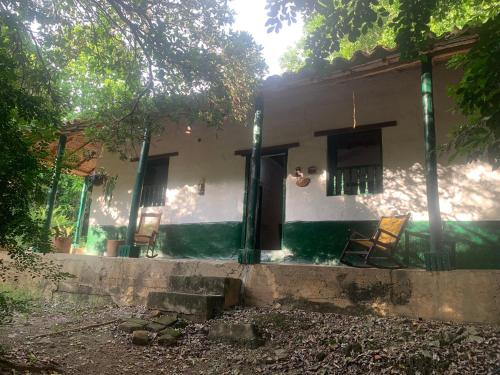 a house with two chairs sitting outside of it at Casa Victoria in Piedecuesta