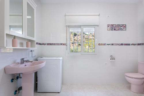 a white bathroom with a sink and a toilet at Villa Felicidad destino romántico in Sayalonga