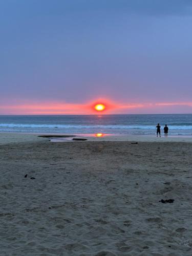 two people walking on the beach at sunset at sun sea 白浜大浜海水浴場 コンビニ徒歩1分 in Shimoda