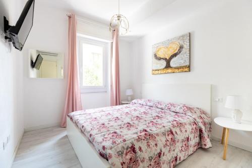 a white bedroom with a bed and a window at La Casa Di Nunù e Iole in Quartu SantʼElena