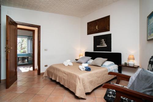 a bedroom with a bed and a chair in a room at Casa Su Craminu in Dorgali
