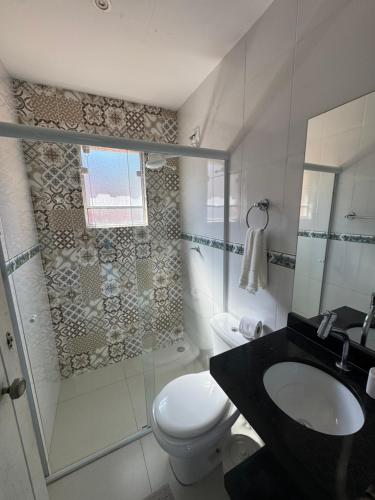a bathroom with a shower and a toilet and a sink at Casa Aconchegante próximo da balsa in Ilhabela