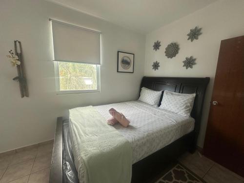 een slaapkamer met een bed met een knuffeldier erop bij White House Paradises in Cabo Rojo