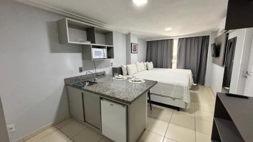a hotel room with a bed and a sink in it at Blue Sunset Home Service - Angela Hospedagens in João Pessoa