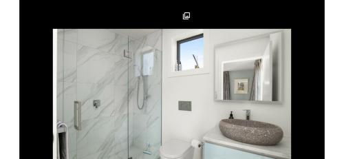 a bathroom with a shower with a sink and a sink at Miners Lane Guest House in Clyde