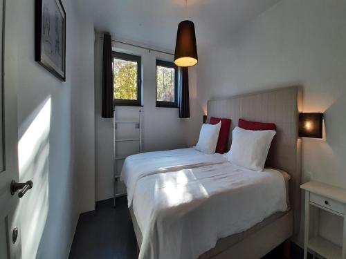 ストゥモンにあるScenic Cottage in Rahierのベッドルーム1室(白いシーツと赤い枕のベッド1台付)