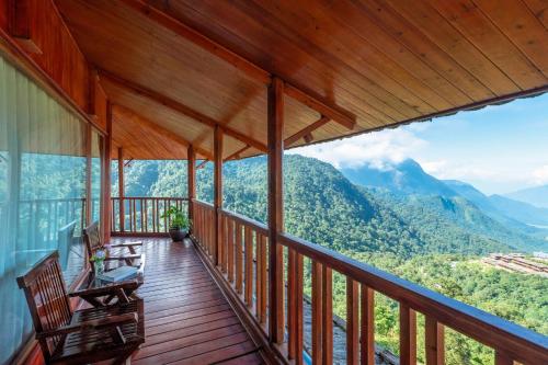 a deck with chairs and a view of mountains at Heaven Gate O Quy Ho Hotel Sapa in Lao Cai