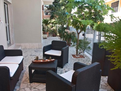 アルバ・アドリアティカにあるAlba D'Abruzzo Bed and Breakfastの木々のあるパティオ(椅子、テーブル付)