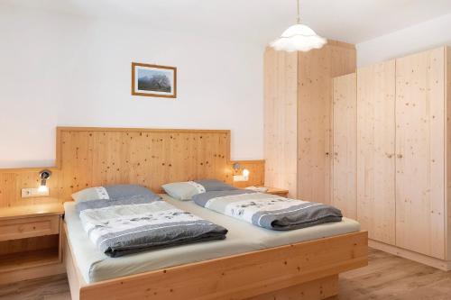 a large bed in a bedroom with wooden walls at Thusnelda Apartment D in Siusi