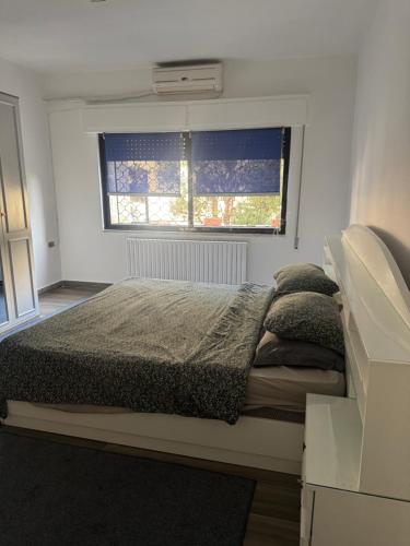 a bedroom with a large bed with a window at Abdoun ground floor apartment in Amman