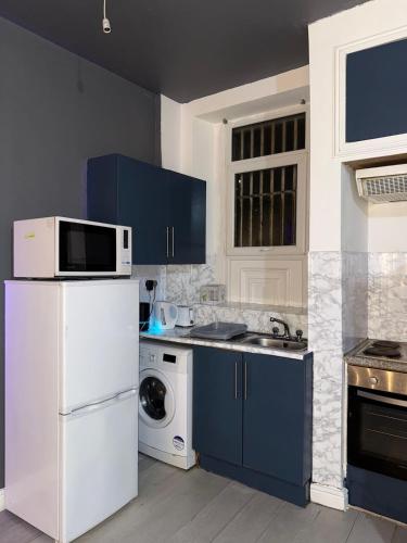 a kitchen with blue cabinets and a white refrigerator at Starlight Nights in Bradford