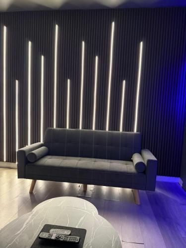 un salon avec un canapé devant un mur éclairé dans l'établissement Starlight Nights, à Bradford
