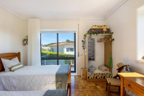 a bedroom with a bed and a view of a balcony at Sobreiro22 in Lourosa