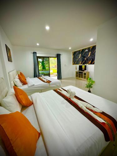 a bedroom with two beds and a room with a window at Da Airport Hotel in Nai Yang Beach