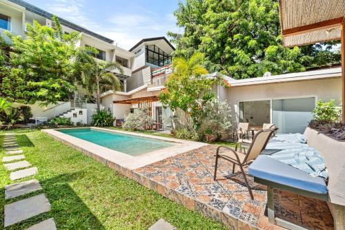 a backyard with a swimming pool and a house at La Ramona Charming Hotel in Tamarindo