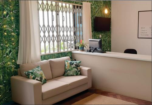 a waiting room with a couch in front of a window at Açaizeiro Hostel in Belém