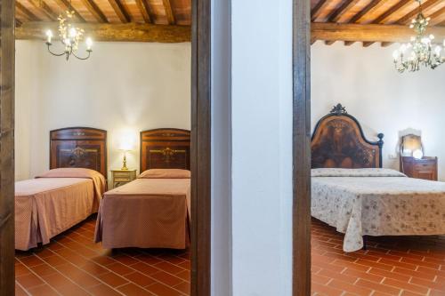 a bedroom with two beds and a mirror at Il Cancellone - Tartaruga in Montiano