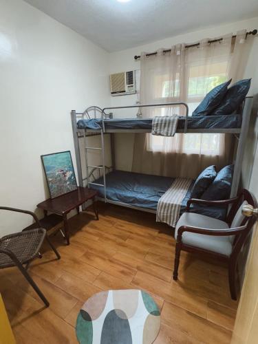 a room with two bunk beds and a chair at 90's Themed 2 Bedroom Unit at Seawind Sasa, Davao City Philippines in Sampong