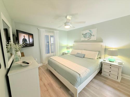 une chambre avec un lit et un ventilateur de plafond dans l'établissement Pelican Beach Resort unit #903, à Destin