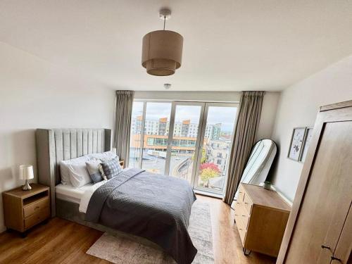 a bedroom with a bed and a large window at Luxury 2-Bed 2-Bath Penthouse with Terrace in Harrow