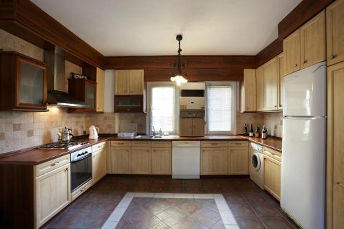 cocina con armarios de madera y nevera blanca en Villa Bosphorus Konak, en Estambul