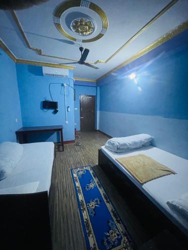 a bedroom with two beds and a blue wall at Sunita Hotel And Lodge in Rāmechhāp