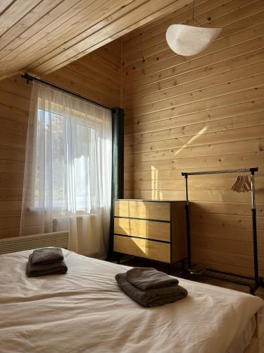 a bedroom with a bed with two towels on it at Lemko Lodge in Novyy Kropivnik